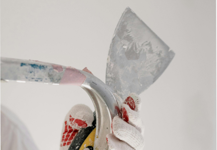 gloved hand with trowel on ladder